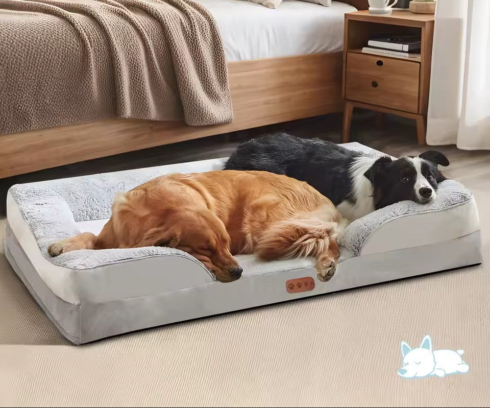 Two dogs resting together on a large gray orthopedic memory-foam dog bed in a cozy bedroom.
