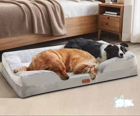 Two dogs resting together on a large gray orthopedic memory-foam dog bed in a cozy bedroom.